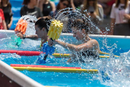 Girls Doing Water Aerobics with Floating Pool Dumbbells Outdoor in a Swimming Pool.