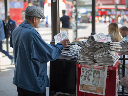 Street Photography: Elderly Newspaper Salesman with a hat in London's Street.の写真素材