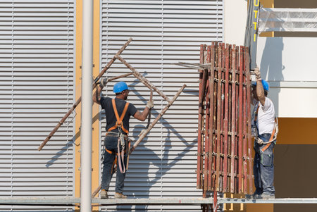 Workers at Work on a Scaffold in a Building Site for the Construction of a Building.