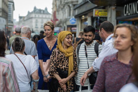 Street Photography: Smiling Tourists of Indian Origins Walking Through the Crowd in London.のeditorial素材