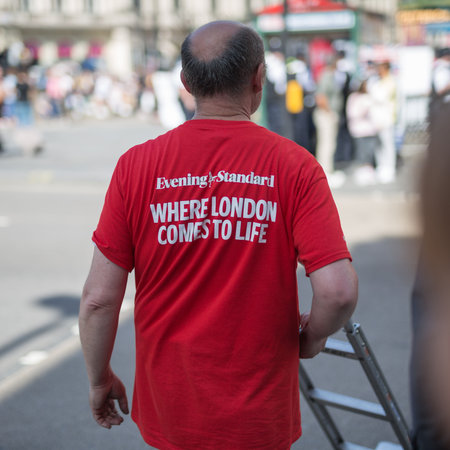 Slogan Written on the Red Shirt of a Man who Delivers Magazines in the Street: ..London comes to Life.のeditorial素材