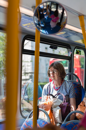 Street Photography: Elderly Lady with Glasses Sitting on City Bus in London.のeditorial素材