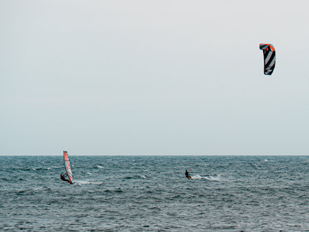 Kitesurfing and Windsurfing During a Windy Day with a Very Rough Sea.