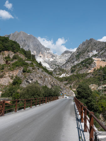 On a Bridge: View of a Mountainside in Carrara in Summer Time with Rocks Covered by Vegetation and Trees.の写真素材