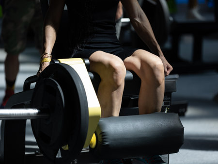 Girl Doing Exercises at Gym: Leg Extensions Workout on Fitness Machine.