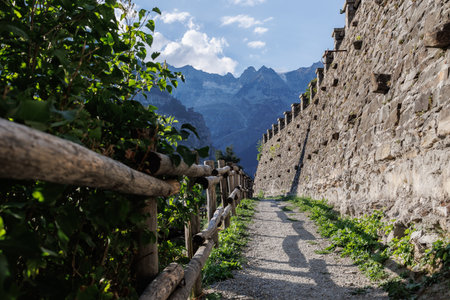 The Walls, the Fence, a Path and the Mountains in the background in Courmayeur in the Aosta Valley - Italy.の写真素材