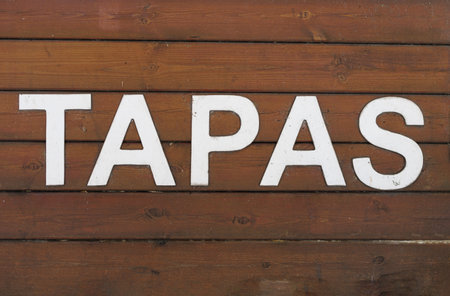 Tapas, an Appetizer or Snack in Spanish Cuisine, White Text on Wooden Background.の写真素材