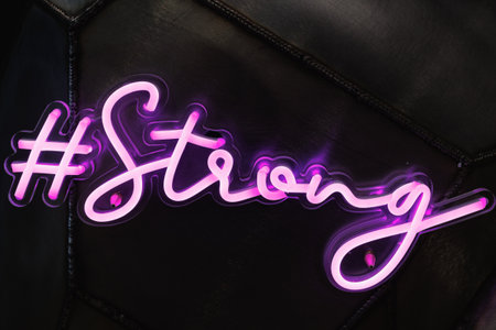 Pink Neon Light with Strong Text on Black Background.の写真素材