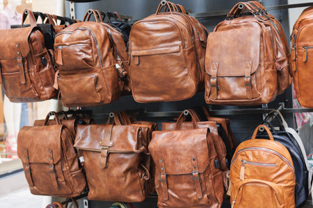 Brown Leather Bags and Backpacks Hanging on a Display Stand.の写真素材