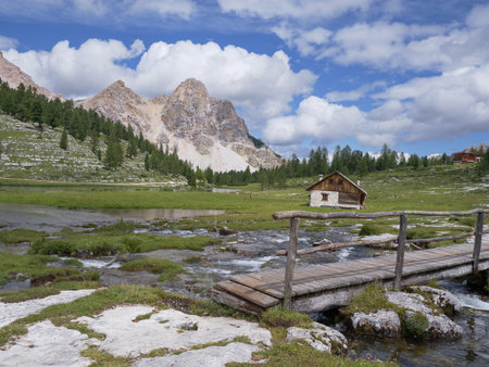 Small Wooden Bridge, Wooden Hut and Le Vert Lake in the Greenery of the Fanes - Senes - Braies Nature Park, Alps Mountains, Italy.の写真素材