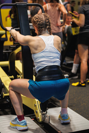 Girl Doing Exercises with Gym Belt attached to his body and to a machine - Fitness Workout.の写真素材