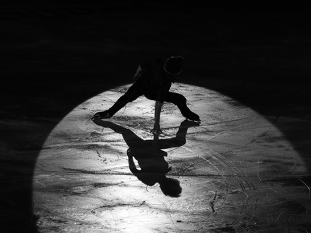 Backlight of an Athlete Skater and the Shadow reflected on the Ice Rink during the Artistic and Technical Performance.の写真素材