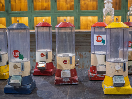 Old Gumball Machines With Colorful Lids On Wooden Table.の写真素材