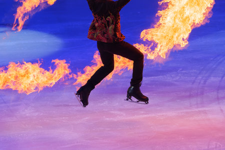 Skater Performing an Artistic Performance on the Ice Rink with Flaming Burning Sticks.
