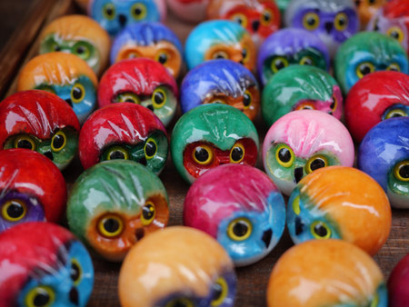 Collection Of Small Colorful Ceramic Owl Figurines On Wood.