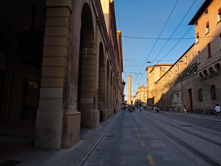 Historic Bologna Street With Tram Tracks And Ancient Buildings Leading Towards Towers - Bologna, Italy.の写真素材