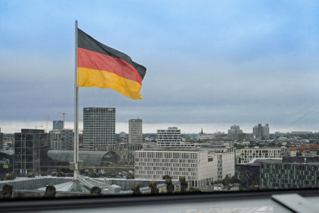 View From Reichstag Dome Roof Terrace, German Flag Waving Over Berlin Cityscape Under Cloudy Sky.の写真素材