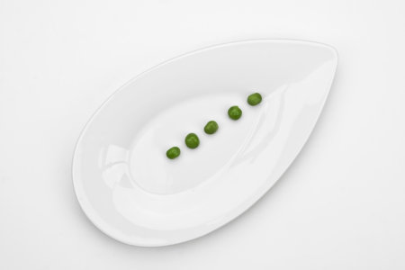 five peas on a white plateの写真素材