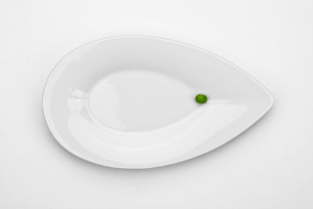 one pea on a white plateの写真素材