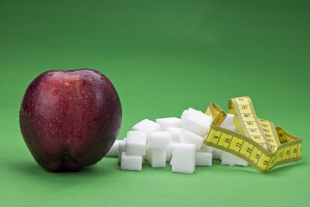 an apple against sugar cubes - healthy versus unhealthyの写真素材