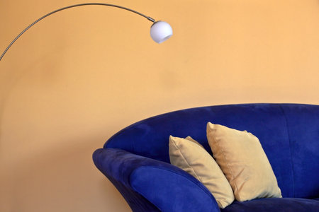 a blue sofa with reading lamp and yellow pillows and wallsの写真素材