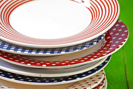 rustic and colorful plates on a green wooden tableの写真素材