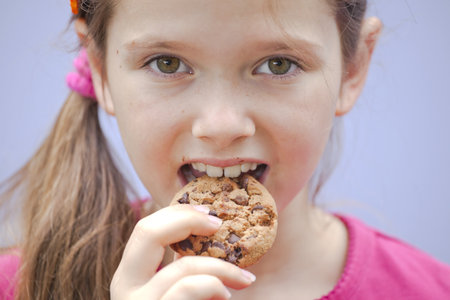 a seven-year-old girl eating chocolate cookiesの写真素材