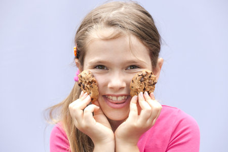 a seven-year-old girl eating chocolate cookiesの写真素材