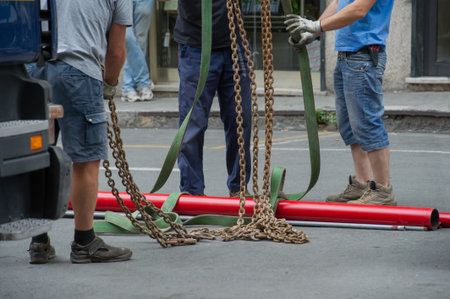 A working group is preparing to lift heavy pipes