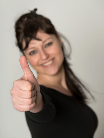 Portrait blurred young woman showing thumbの写真素材