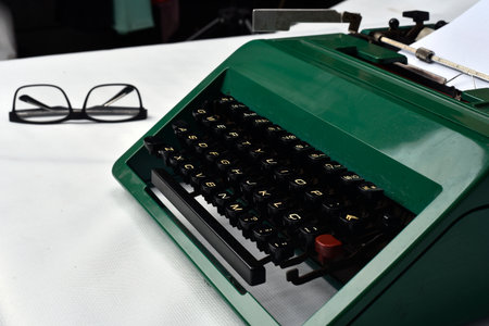 Retro Antique Typewriter with Paper and Glasses Beside on White Backgroundの写真素材