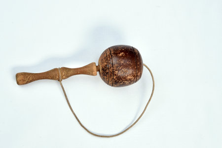 toy, old, brazilian, wooden ball tied by a rope on white background