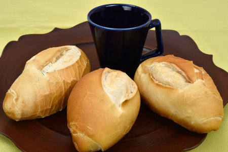 french bread on the plate with black cup in the background.の写真素材