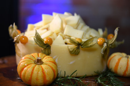 cheese with small pumpkins on wooden table with herbs and pepperの写真素材