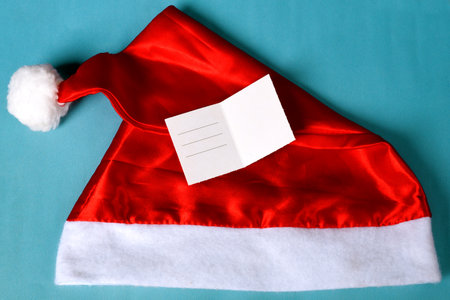 Santa's hat with blank card to write christmas message on blue backgroundの写真素材