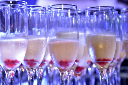 sparkling champagne drinks in crystal glass with blue light for blurred texture background with...