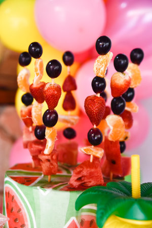 delicious skewer of colorful tropical fruits on blurred backgroundの写真素材