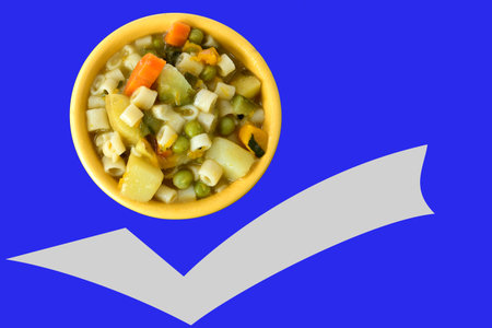 Soup bowl with pasta, beans and vegetables on blue background with space for text and advertisementの写真素材