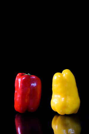 natural yellow and red pepper isolated on black backgroundの写真素材