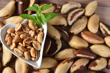 Brazil nuts on the table with a pot of peanuts on the side, typical Brazilian fruit