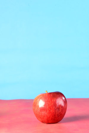 beautiful red apples seen from the side isolated on yellow and blue background, healthy natural...