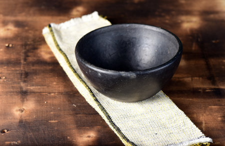 brown clay colored rustic porcelain cup isolated on wooden backgroundの写真素材
