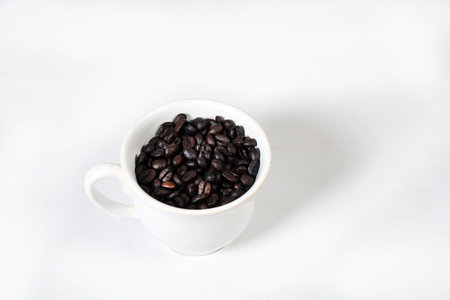 white cup with roasted coffee beans isolated with copy spaceの写真素材