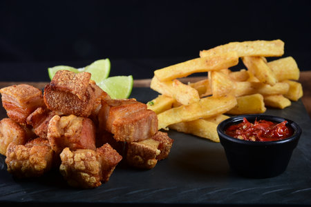 pork cracklings with fried cassava and lemon pork baconの写真素材