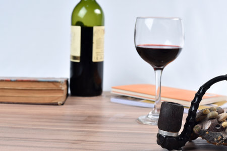 bottle of red wine with pipe and old bookの写真素材