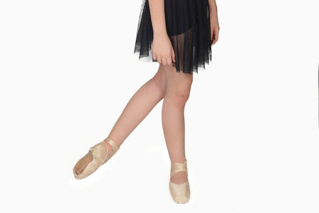 Ballerina legs in pointe shoes closeup on white background. Classic and modern ballet concept with...