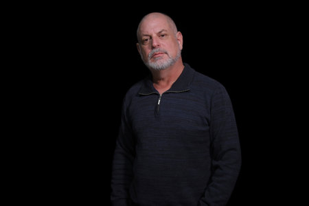 portrait of older bearded man pensive and watching isolated on black background