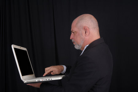 Handsome middle-aged man in a white shirt suit against black background. confident business man...