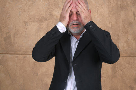 Portrait of pensive middle age businessman thinking about business project at workplace, young businessman with pensive face expression daydreaming, closeup shotの写真素材