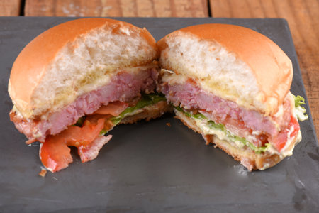 hamburger sandwich with melted cheese lettuce tomato mayonnaise and bread delicious fast food traditional snackの写真素材